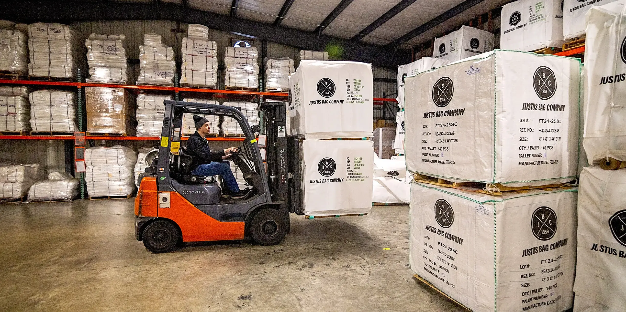 improving-our-program A man moving pallets of custom bags with a forklift