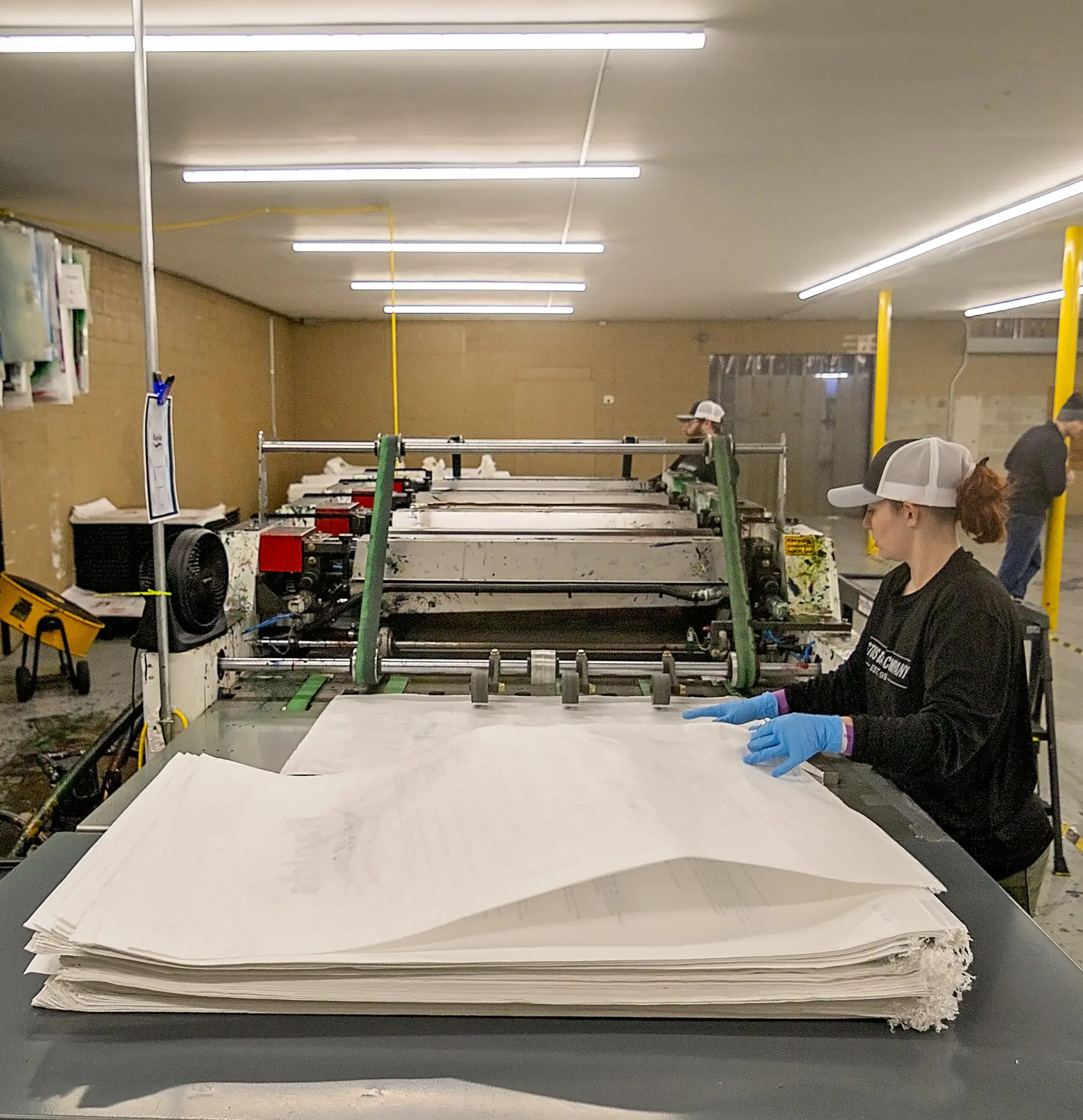 stay-the-same-about A woman working on printing bags