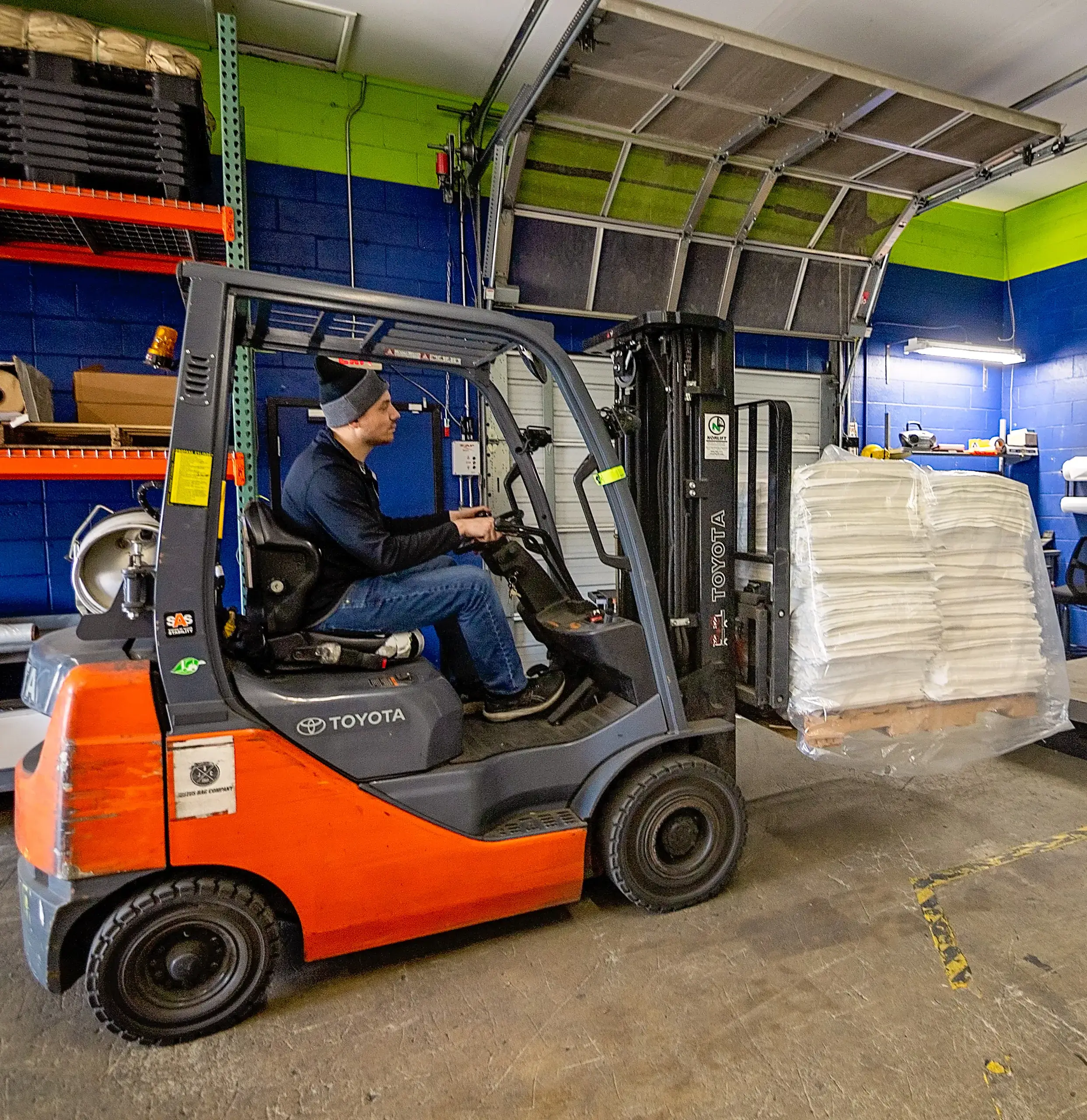 A team member moving a pallet of bags with a forklift